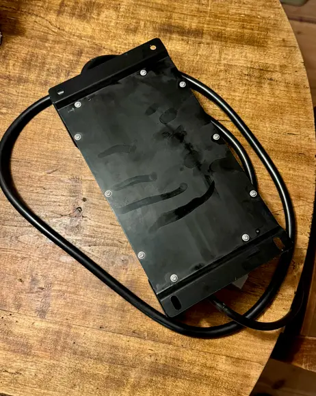 The battery box closed, sitting on a workbench