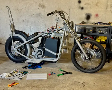 The bike further along, standing on its wheels in the garage